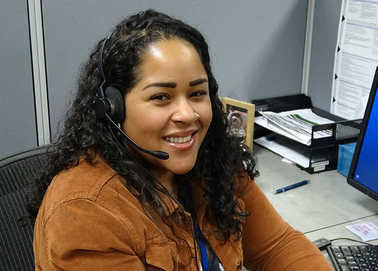 Female Spectrum Call Center Representative wearing a tan jacket wearing a telephone headset